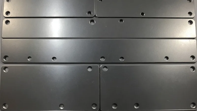 Close-up camera view of stamped metal part with annotated defect regions